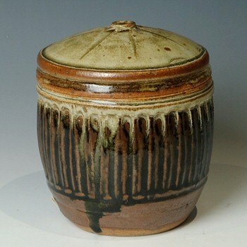 Stoneware caddy, rilled cylindrical sides with star pattern on lid.