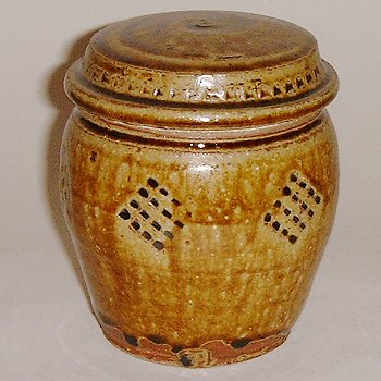 Small covered jar with incised decoration and spiral pattern.