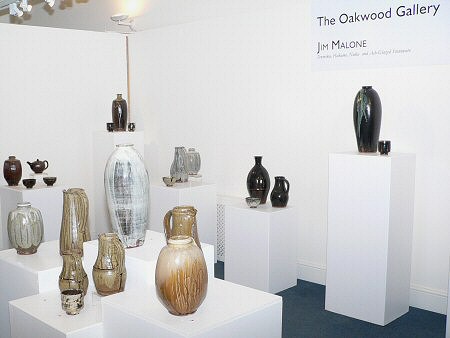 Exhibition pots, tall temmoku glazed bottle vase with copper pours rightly on the highest pedestal