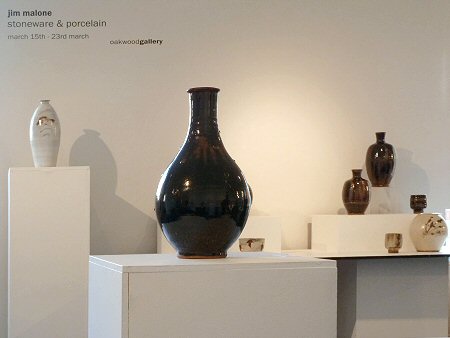 View across the exhibition, temmoku glazed Korean bottle in foreground