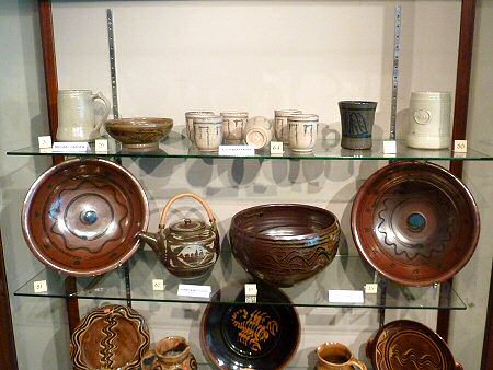 Top row - Set of beakers by Alix Woffenden surrounded by Michael Cardew pots. Bottom row - Harry Davis teapot surrouned by Ray Finch pots