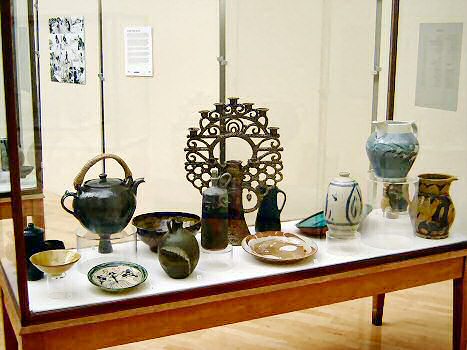 The Functional Case - Including an early Bernard Leach raku dish, a Katherine Pleydell-Bouverie stoneware vase with blue decoration and a Michael Cardew tea pot