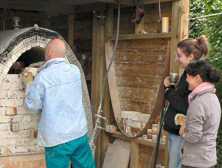 Jack Doherty removing the bricks with potters Kat Livesey  and Midori looking on