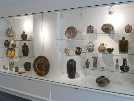 The new display case in the entrance area currently showing historical pots made at the Leach Pottery