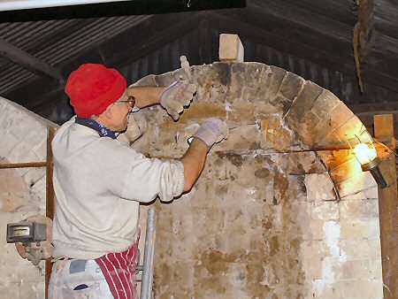Jeremy Leach checking kiln temperature through a spyhole
