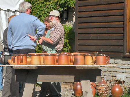 John Leach in hat, behind a pallet of pots